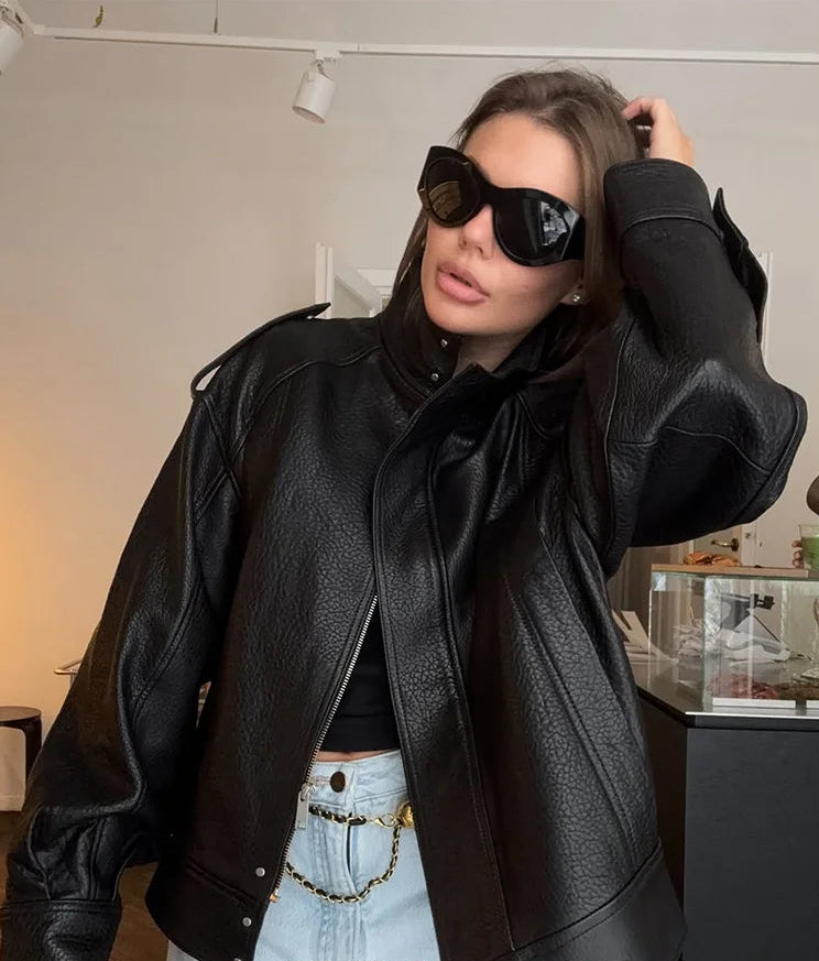 Woman wearing a black leather jacket and sunglasses indoors, with 'KONDALA' branding.