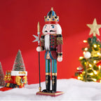 Decorative nutcracker figure with a crown in front of a Christmas tree and red background