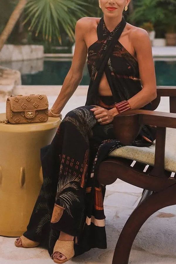 Woman in a black dress sitting on a bench with a brown handbag next to her.