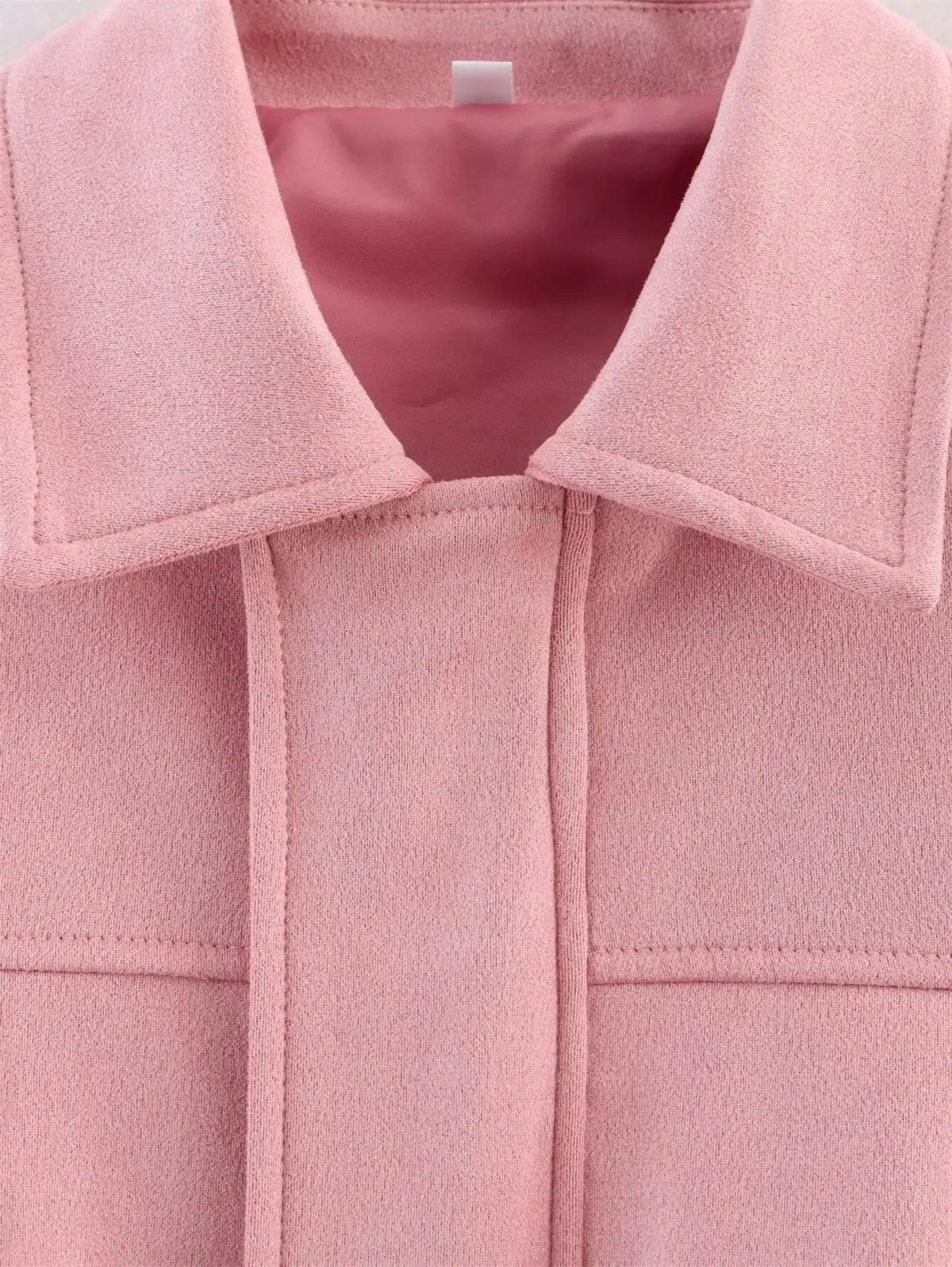 Close-up of a pink coat with a collar and button details.