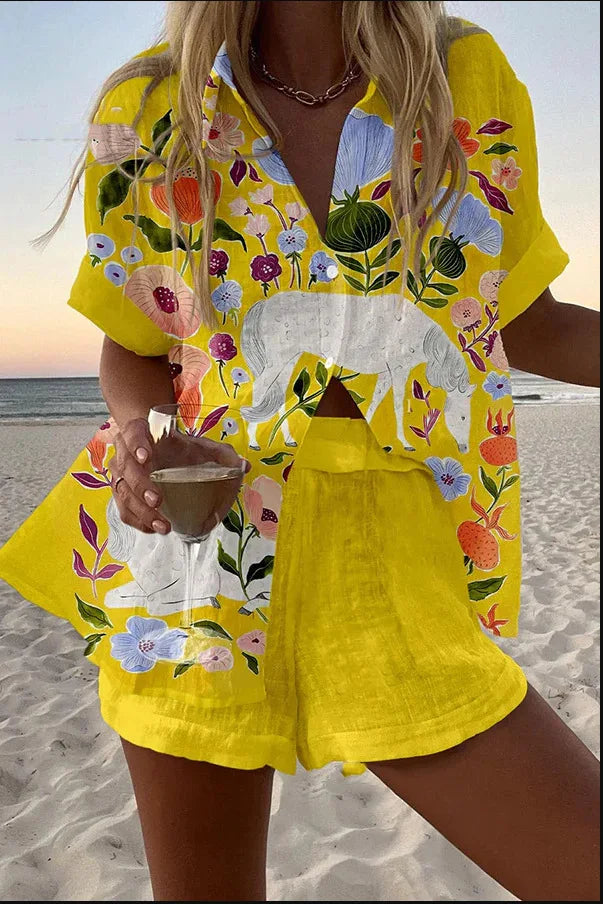 Person wearing a yellow floral outfit on a beach.
