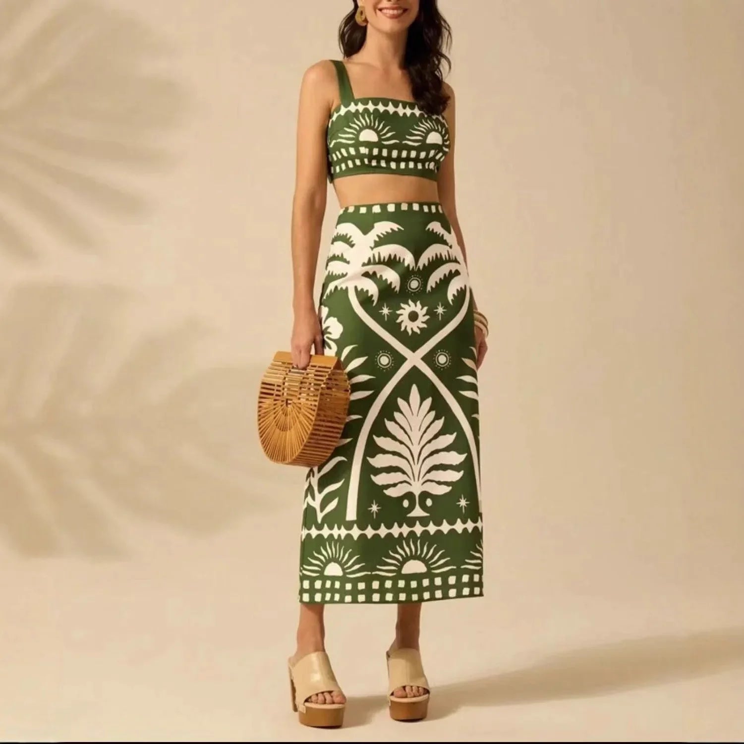 Woman wearing a green and white patterned dress holding a woven bag on a beige background