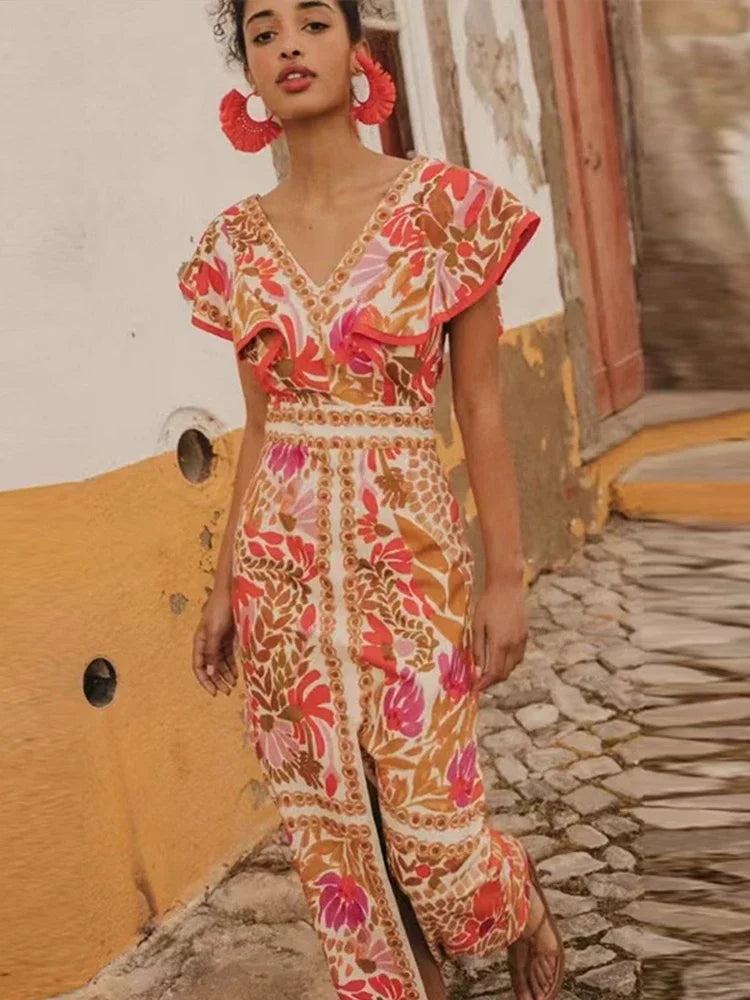 Woman wearing a colorful patterned outfit standing on a stone path.