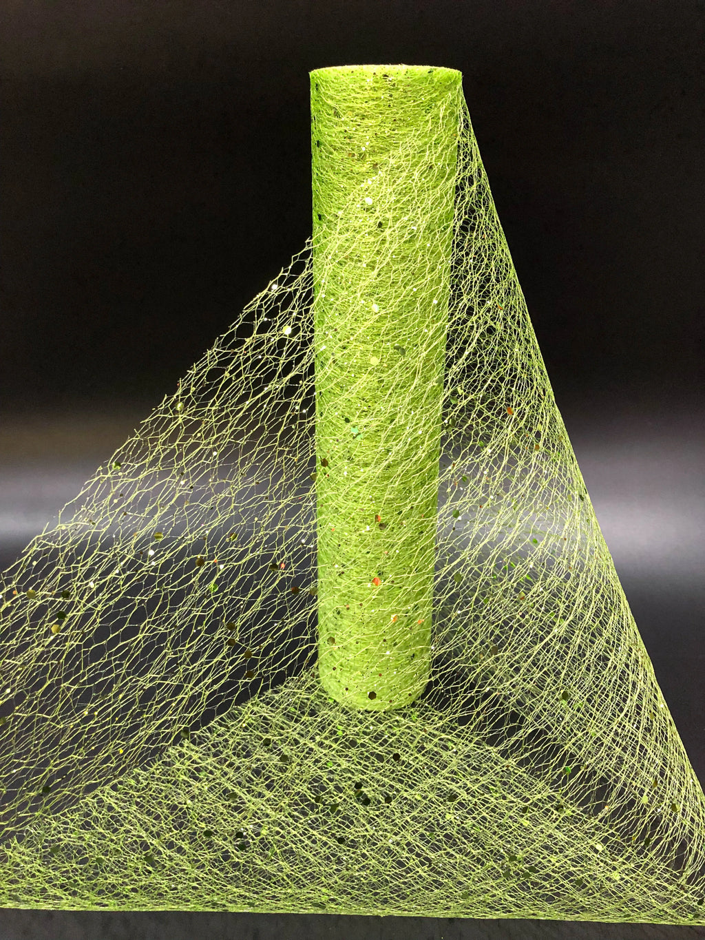 Green mesh fabric with a cylindrical green object on a black background