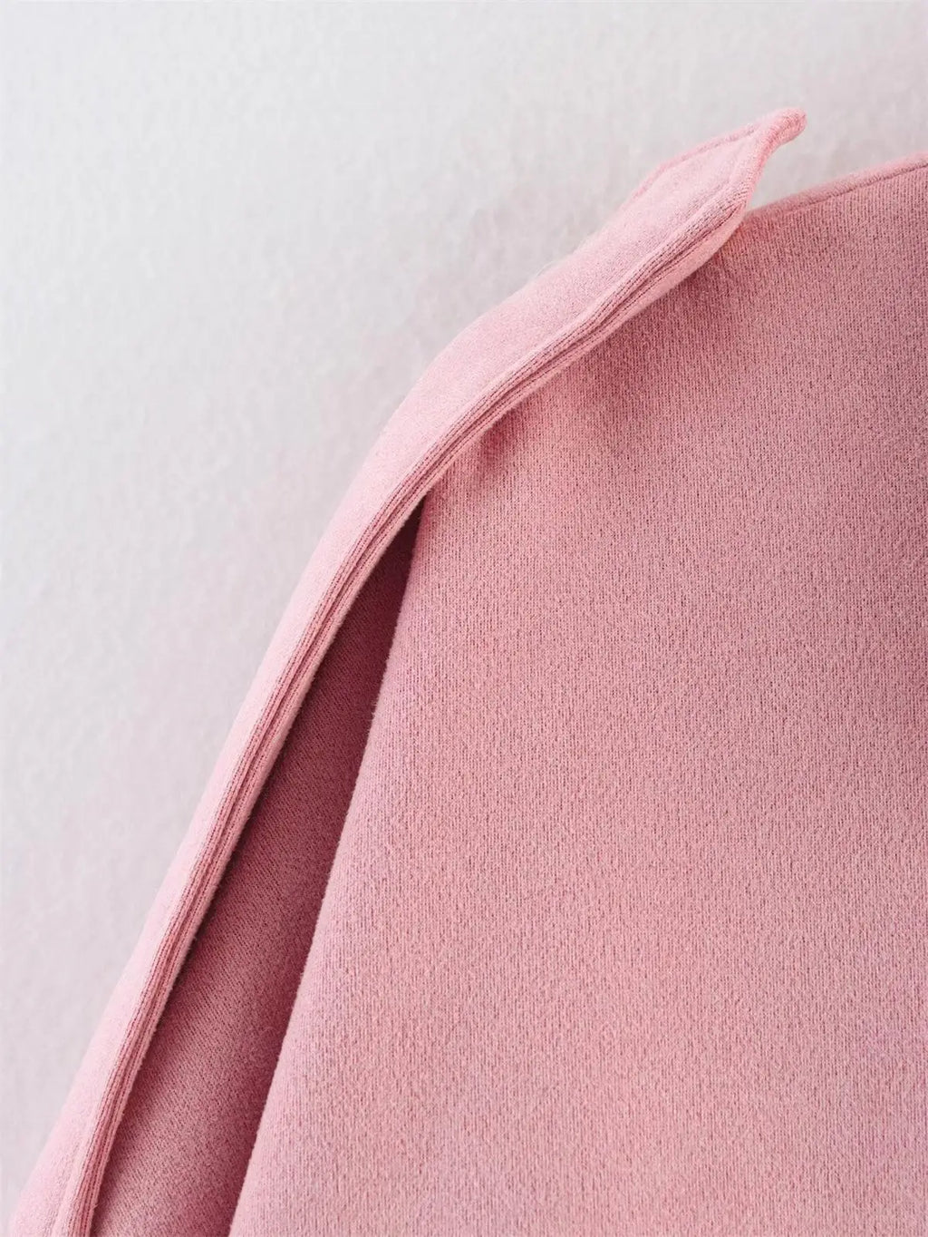 Close-up of a pink fabric texture on a light gray background