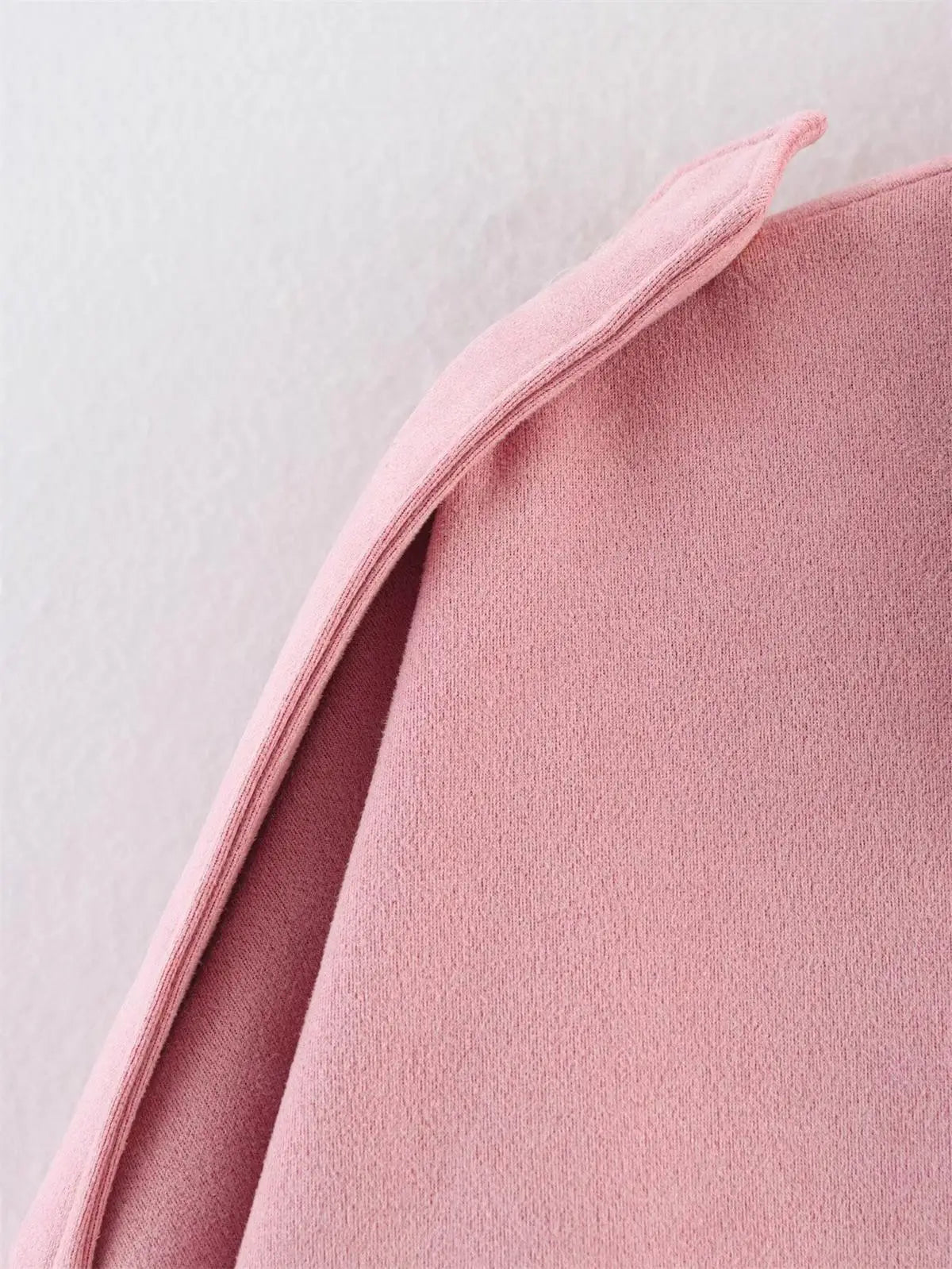 Close-up of a pink fabric texture on a light gray background
