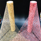 Two rolls of decorative mesh, one beige and one pink with glitter, on a dark background.