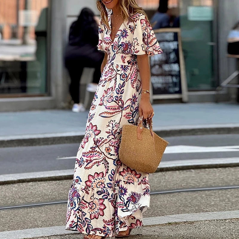 Woman wearing a floral dress holding a straw bag on a city street.