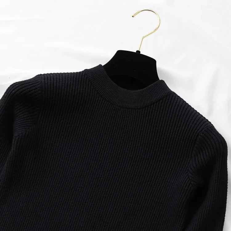 Black sweater on a gold hanger against a white background