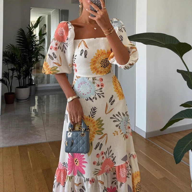 Person wearing a floral dress with a blue handbag indoors.