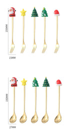 Set of gold Christmas-themed spoons with decorative ends on a white background