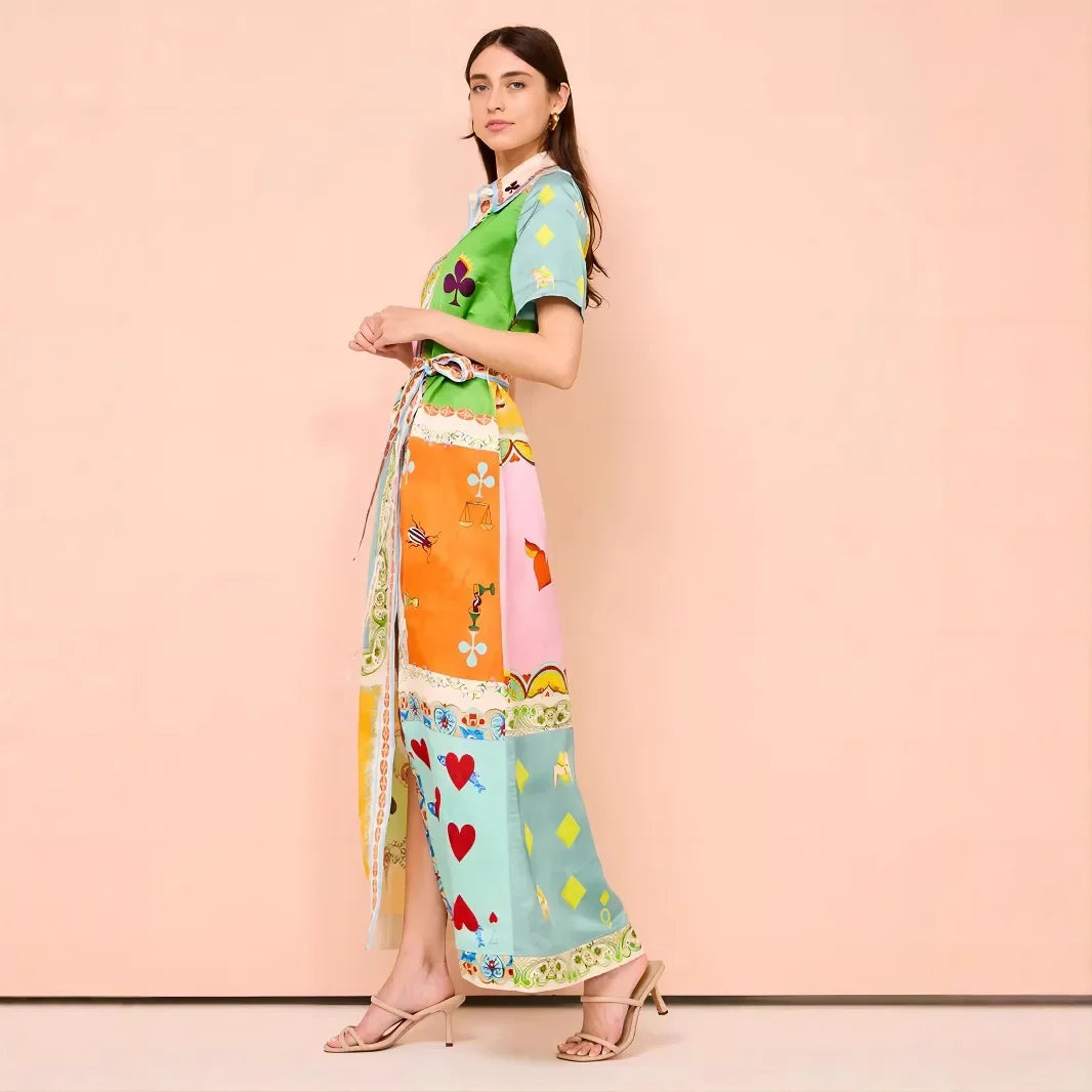 Woman wearing a colorful dress with a patterned scarf on a pink background