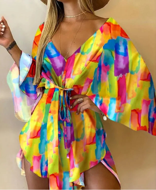 Woman wearing a colorful tie-dye dress against a beige background