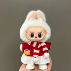 Toy figure of a rabbit wearing a red sweater with white stripes on a gray background