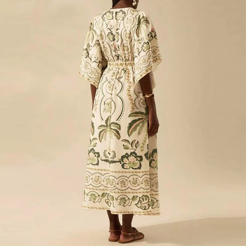 Woman wearing a long, patterned dress against a beige background