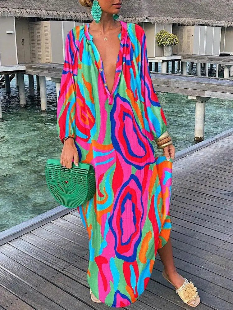 Person wearing a colorful patterned dress on a wooden dock by water.