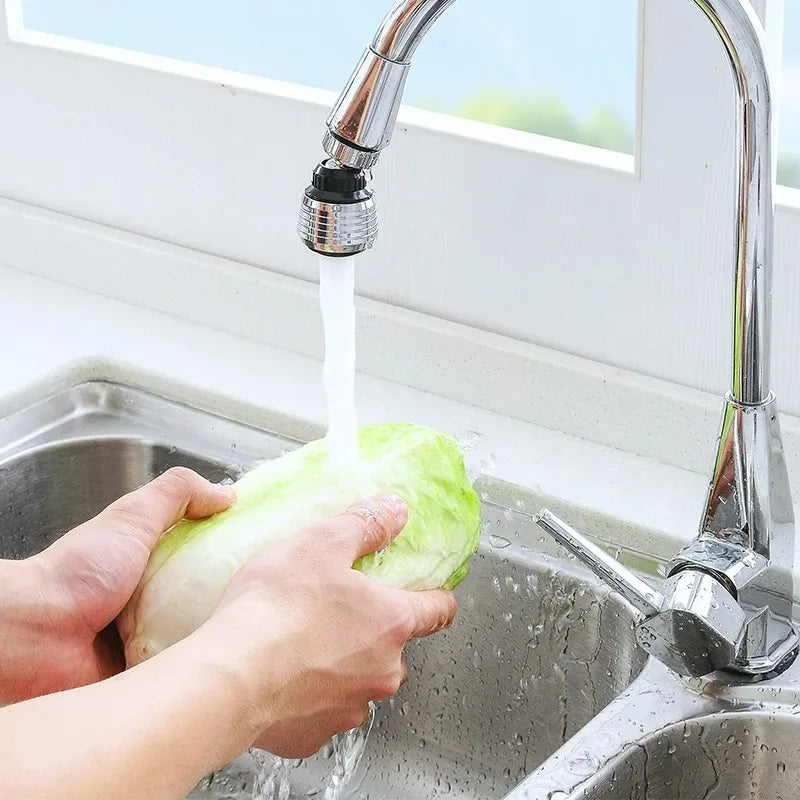 Person washing a head of lettuce under running water from a kitchen faucet.