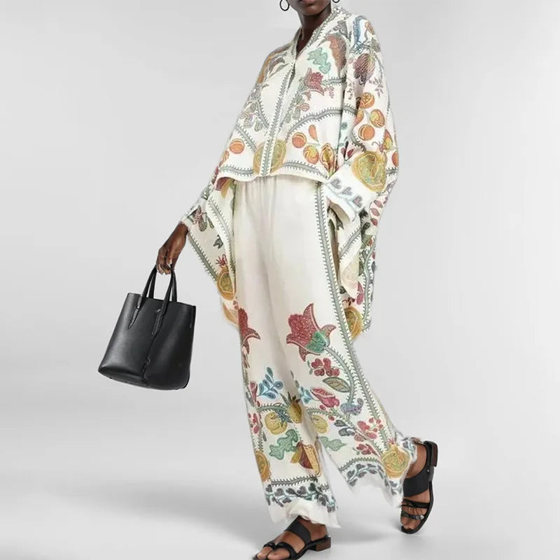 Person wearing a floral embroidered outfit with a black handbag on a white background