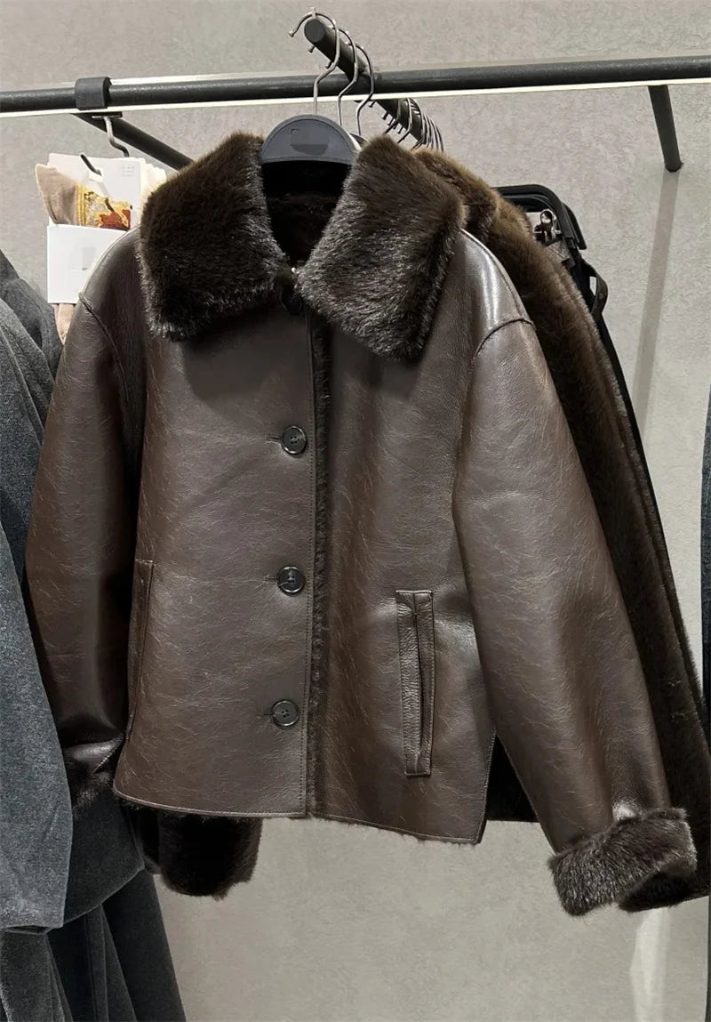 Brown leather jacket with fur collar on a rack