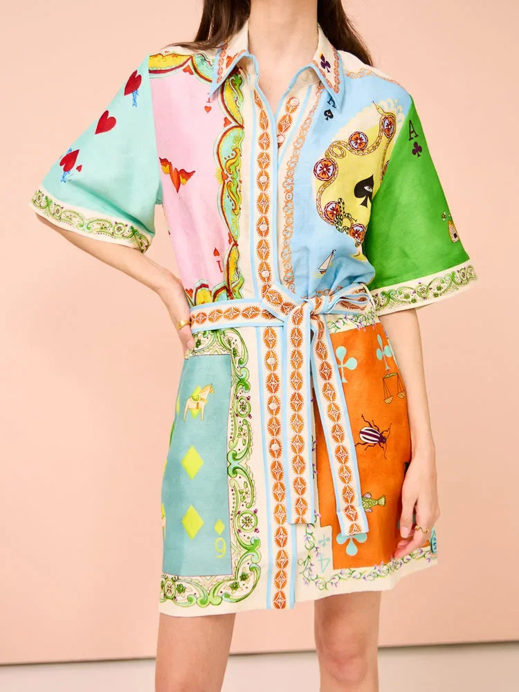 Colorful patterned dress with a belt on a peach background