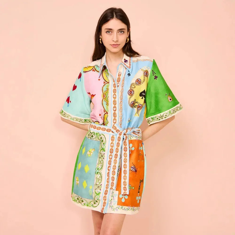 Woman wearing a colorful patterned dress on a pink background