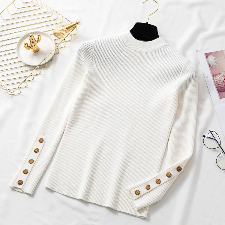 White sweater with button details on a white surface