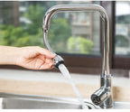 Person using a kitchen faucet with a flexible hose to wash dishes.