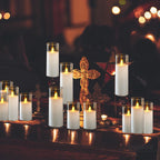Candles in glass holders on a dark surface with blurred lights in the background