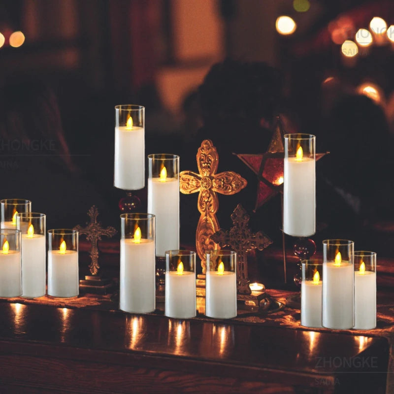Candles in glass holders on a dark surface with blurred lights in the background