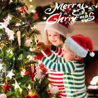 Two children in striped pajamas and Santa hats decorating a Christmas tree with 'Merry Christmas' text above.