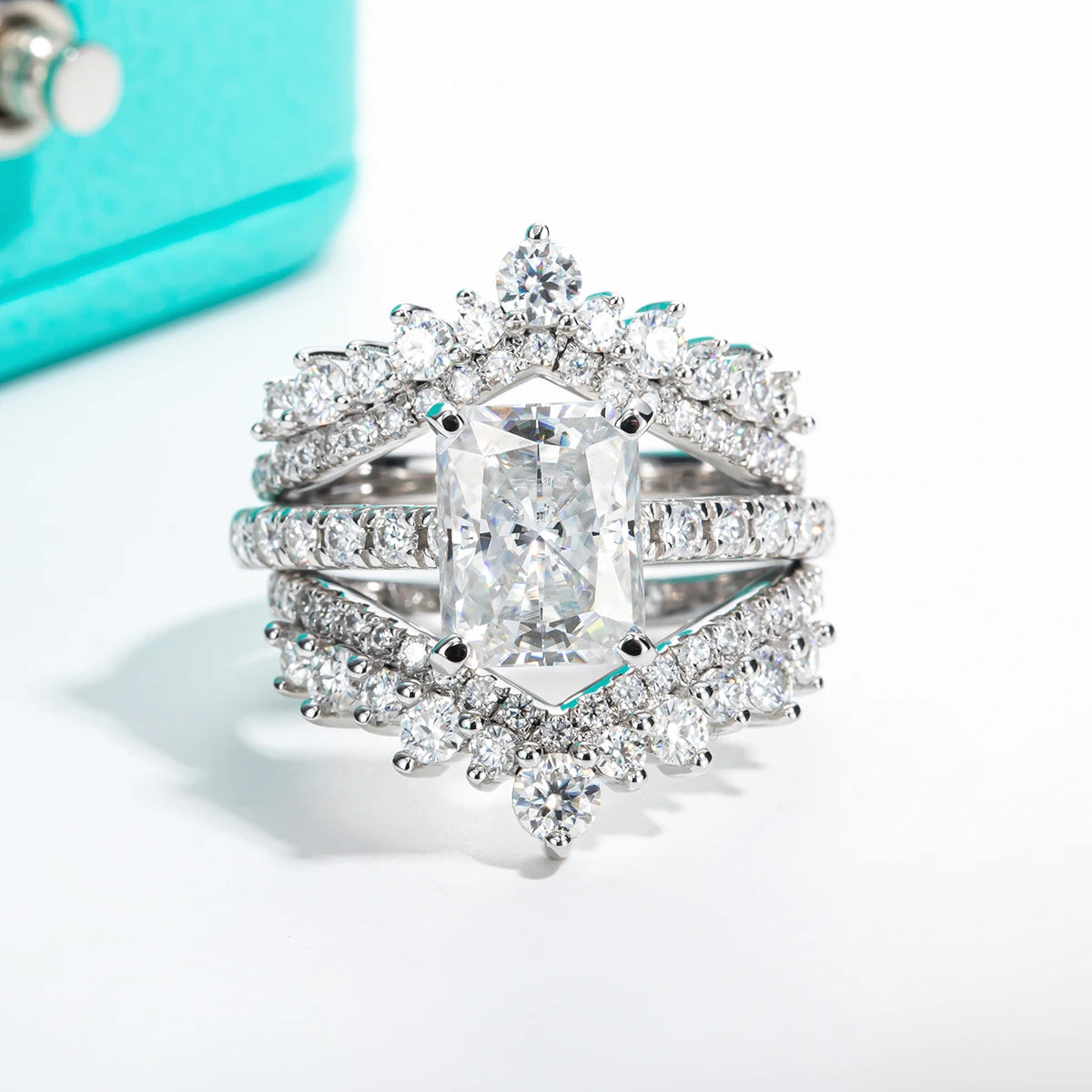 Stack of diamond rings on a white surface with a Tiffany & Co. box in the background.