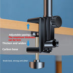 Black clamp with adjustable features on a wooden surface against a blue background