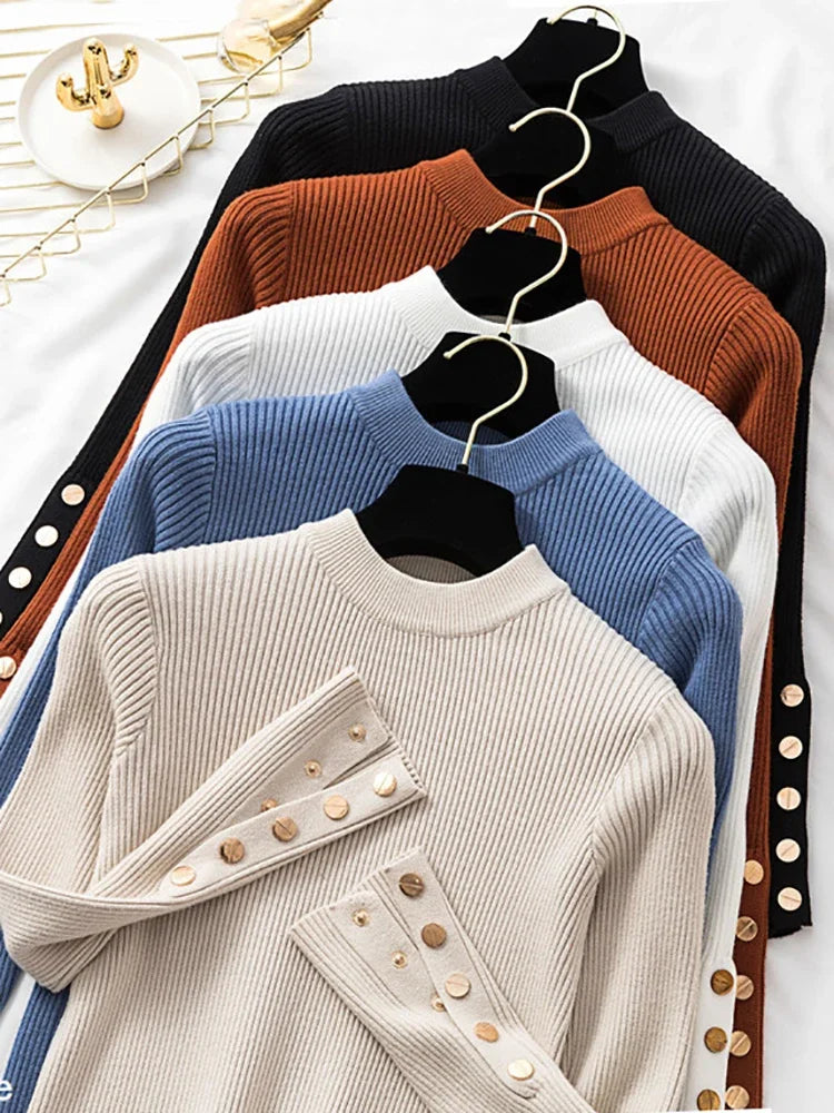 Collection of sweaters in black, brown, white, and blue on hangers against a white background.