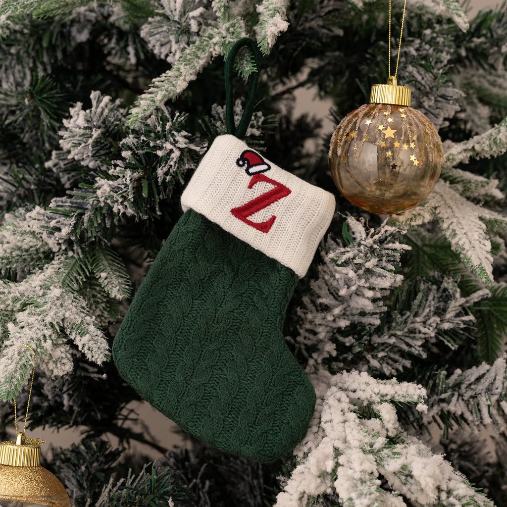 Green Christmas stocking with 'Z' hanging on a decorated tree