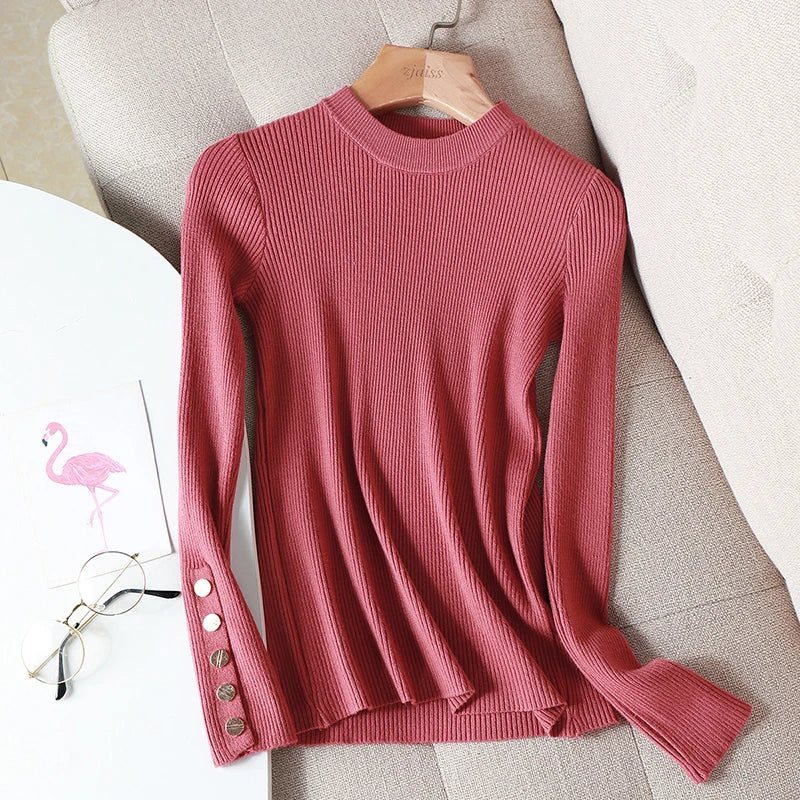 Pink ribbed sweater on a hanger with a white surface and pink flamingo toy in the background