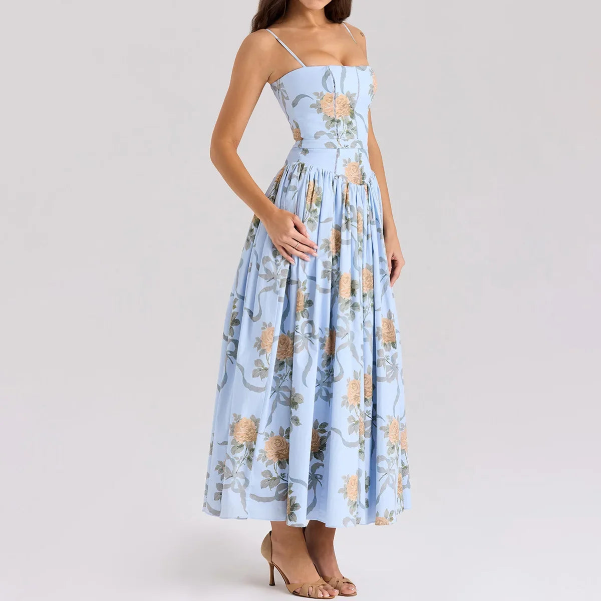 Woman wearing a light blue floral dress on a plain background