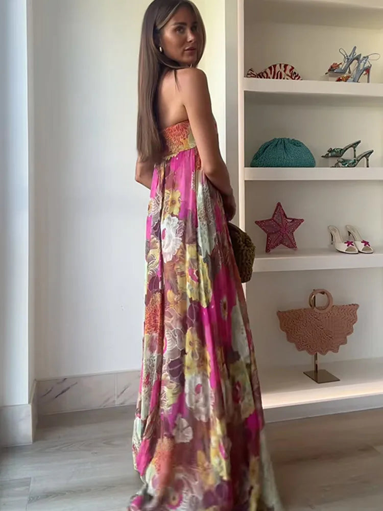 Woman in a floral dress standing in a room with shelves displaying various items.
