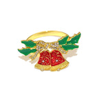 Gold ring with red bells and green leaves on a white background