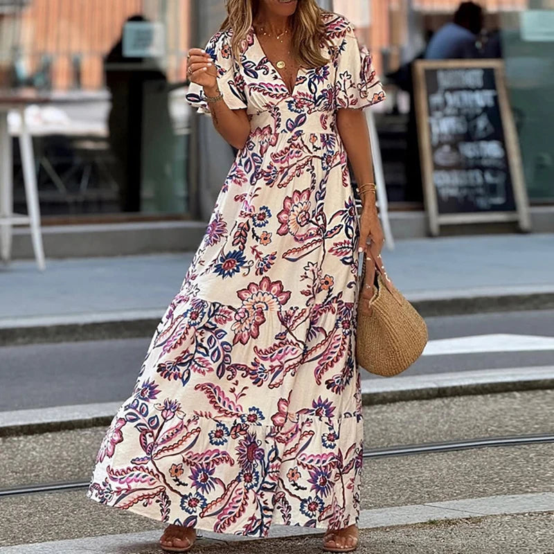Woman wearing a floral dress walking on a street.