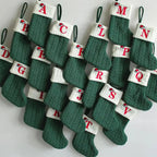 Set of green Christmas stockings with alphabet labels on a white background
