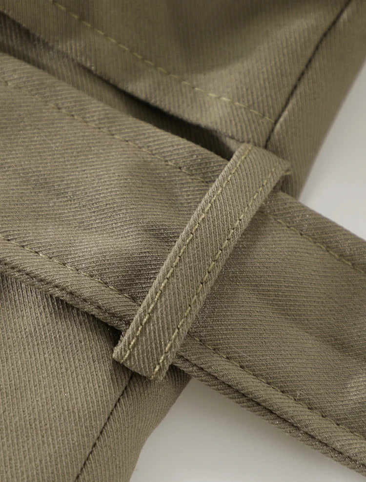 Close-up of a brown fabric with stitching detail on a white background