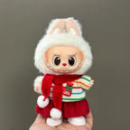 Toy figure of a character wearing a white hood, red scarf, and striped sweater on a gray background