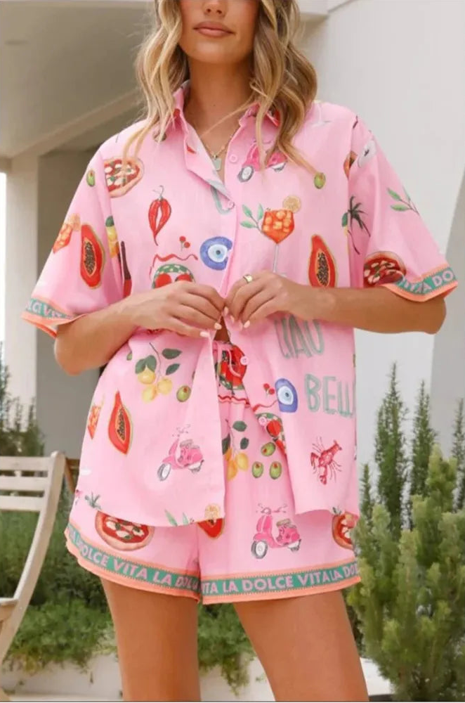 Woman wearing a pink outfit with colorful prints outdoors.