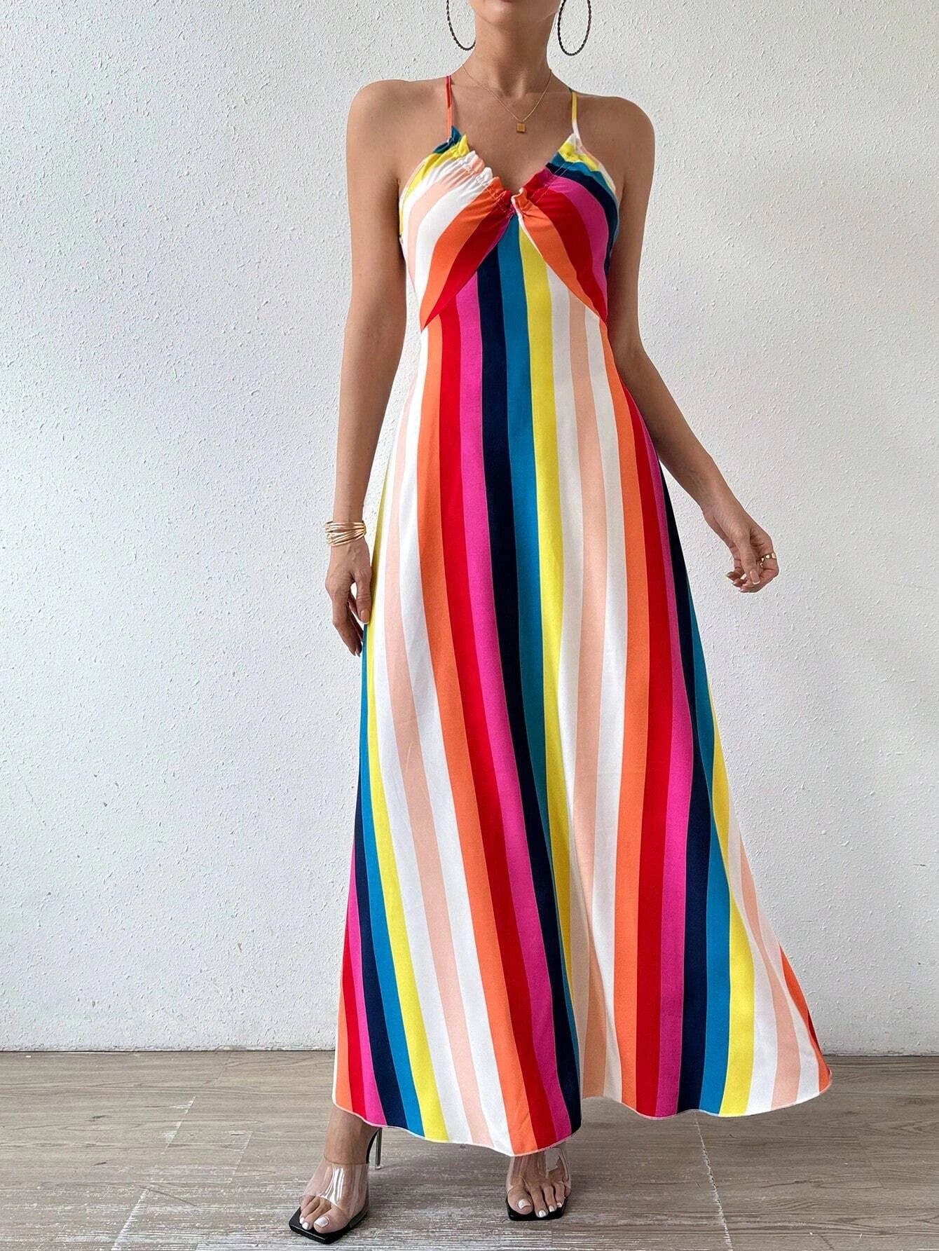 Woman wearing a colorful striped dress against a plain background