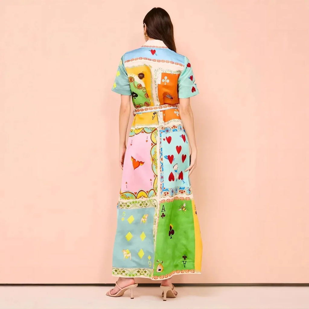 Woman wearing a colorful patchwork dress against a pink background