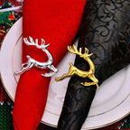 Silver and gold reindeer napkin holders on red and black napkins with a decorative plate.
