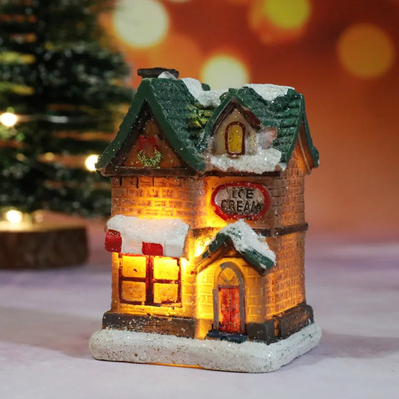 Decorative ice cream shop model with snow on top, glowing warmly against a blurred festive background.