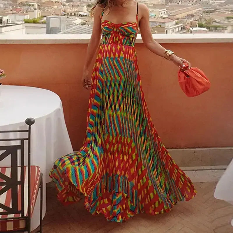 Woman in a colorful dress standing on a rooftop with a cityscape view.