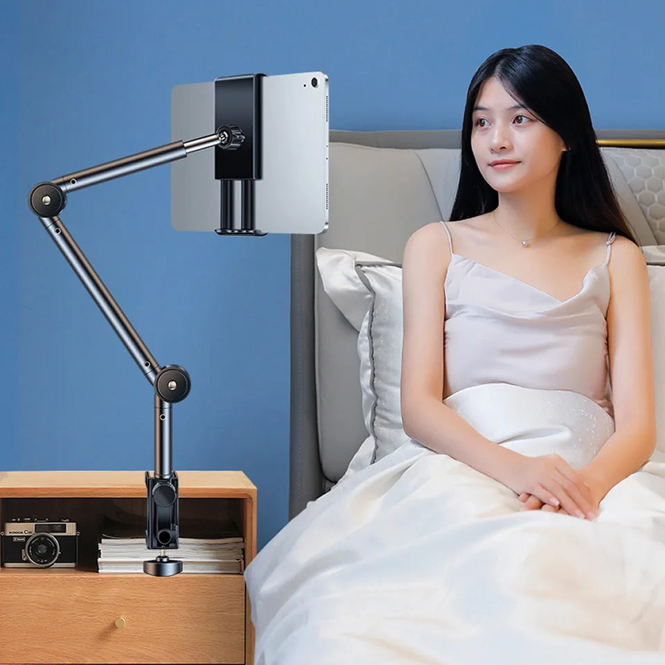 Woman sitting on a bed with a tablet holder attached to a nightstand.