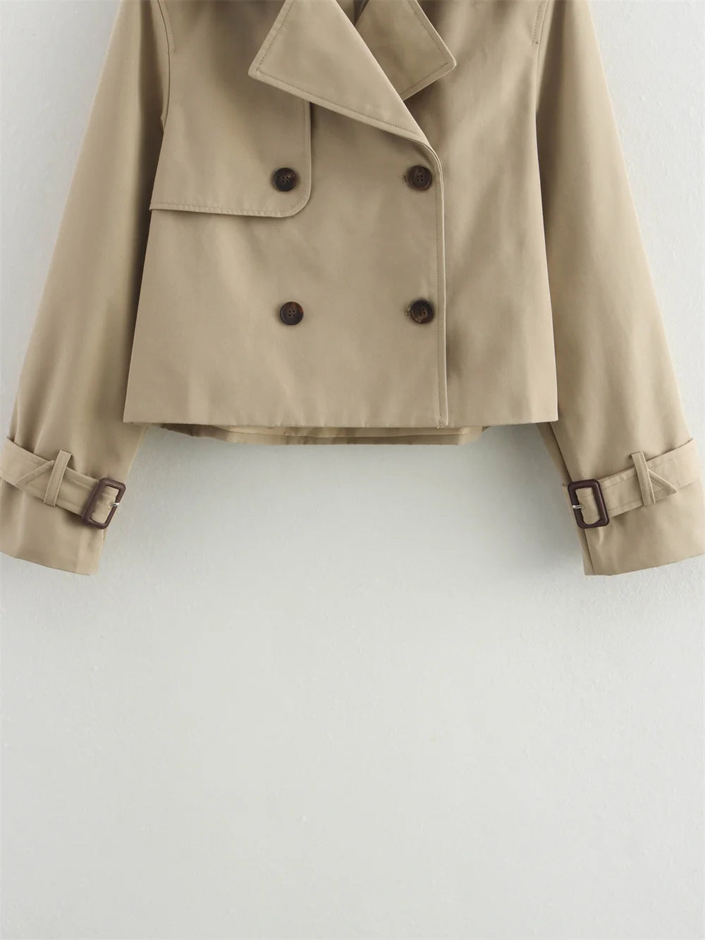 Beige trench coat with button details on a light gray background